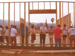 Group of teens framing a wall on a construction site